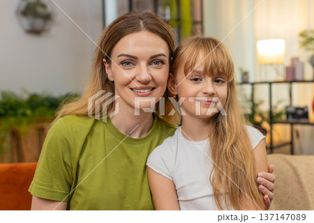 Mother daughter portrait smiling to camera warm family bond gentle pose clean classic style natural 137147089