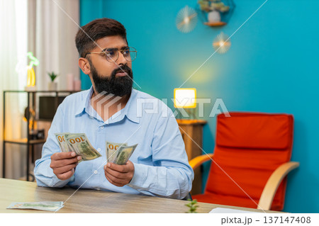 Indian man count dollars money cash banknotes feel wealthy salary profit extra winnings game jackpot Indian man count dollars money cash banknotes feel wealthy salary profit extra winnings game jackpot 137147408