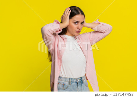 Woman covers ears with hands grimacing refusing to hear bad news avoiding unpleasant negative sound 137147458
