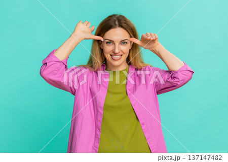 Woman sticking out tongue teasing with playful expression showing fun joke or mild mocking gesture Woman sticking out tongue teasing with playful expression showing fun joke or mild mocking gesture 137147482
