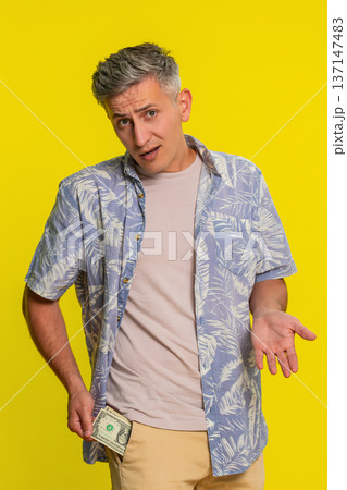 Man pulling out last dollar bills from pocket and spreading hands showing broke or no money gesture Man pulling out last dollar bills from pocket and spreading hands showing broke or no money gesture 137147483