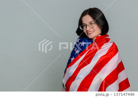 Young woman joyfully waving American USA flag with smile expressing patriotism support pride emotion Young woman joyfully waving American USA flag with smile expressing patriotism support pride emotion 137147490