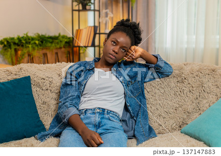 African American woman stressed on sofa thinking after bad day, financial failure or personal issues 137147883