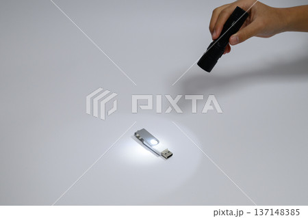 USBメモリを懐中電灯で照らす様子 137148385