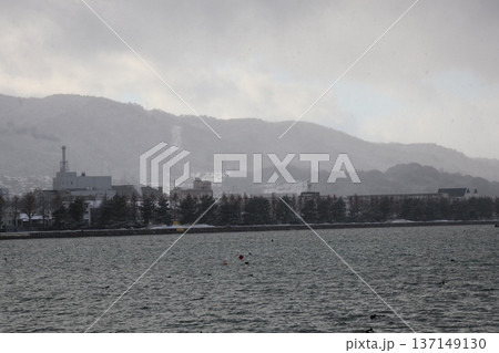 雪の日の琵琶湖と対岸の街と山と空の風景 雪の日の琵琶湖と対岸の街と山と空の風景 137149130