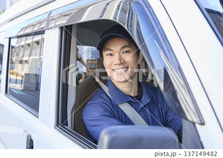 配送車の運転席で笑顔を見せるドライバー 137149482