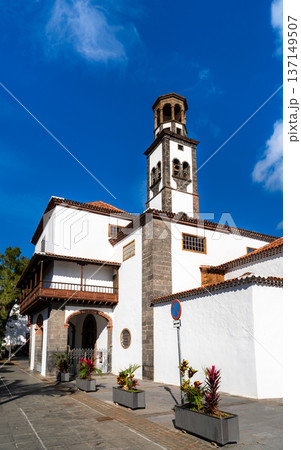 Scenic sunny view of the historic white facade, wooden balcony, and stone bell tower of Iglesia de la Concepcion in Santa Cruz de Tenerife, Canary Islands. 137149507