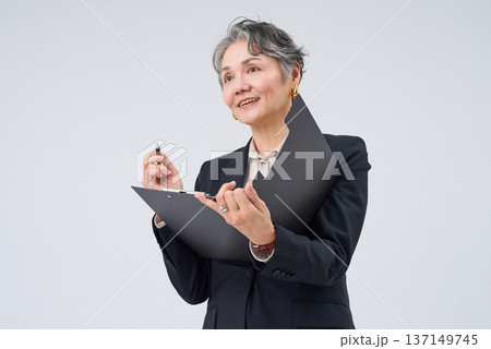 筆記具とファイルを手にするシニア世代のビジネスウーマン 137149745