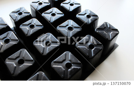 Lower Part Of Black Plastic Cells Of Tray On White Surface Lower Part Of Black Plastic Cells Of Tray On White Surface 137150070