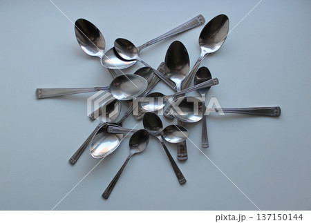 Heap Of Table Spoons And Dessert Spoons On White Plastic Cutting Board. Eating Utensils Concept Design Heap Of Table Spoons And Dessert Spoons On White Plastic Cutting Board. Eating Utensils Concept Design 137150144