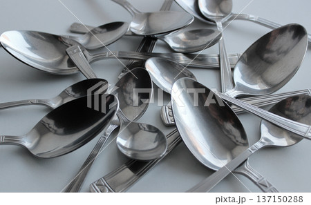 Pattern of spoons of different sizes scattered on a plastic cutting board 137150288