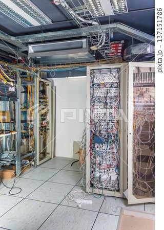 server room rack with tangled network cables creating messy unti 137151786