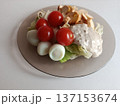 Fresh garden salad with crisp lettuce, juicy cherry tomatoes, halved quail eggs, crunchy croutons and savory dressing on a neutral plate - a healthy, colorful appetizer or light meal 137153674