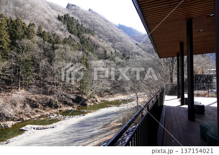 テラスのある施設から見る山間の渓谷とその間を流れる清流の河原 137154021