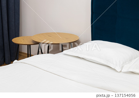 Modern bedroom interior with crisp white bedding and stylish wooden side tables Modern bedroom interior with crisp white bedding and stylish wooden side tables 137154056