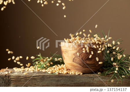 Flying peeled pine nuts on a brown background. Flying peeled pine nuts on a brown background. 137154137