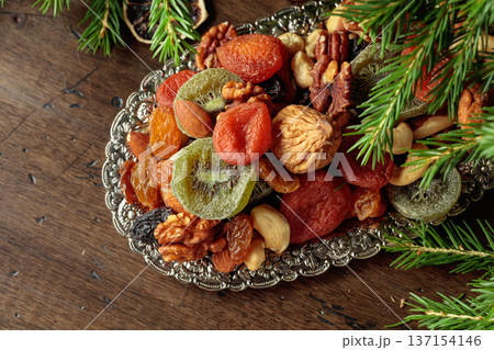 Assorted dried fruits and nuts on a silver tray. 137154146