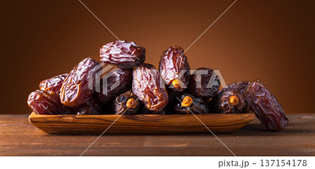 Juicy ripe dates on an old wooden table. Juicy ripe dates on an old wooden table. 137154178