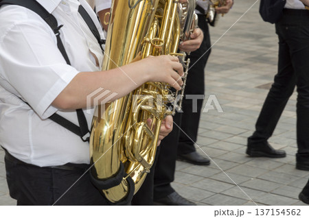 music band with person in the foreground playing the saxophone music band with person in the foreground playing the saxophone 137154562