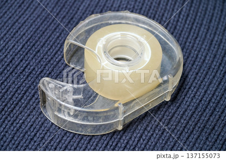 A used adhesive tape dispenser for the office 137155073
