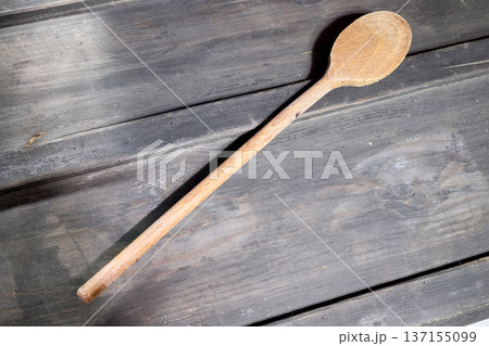 wooden spatula against a black wood background wooden spatula against a black wood background 137155099