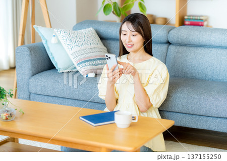 部屋でスマホを操作する女性 部屋でスマホを操作する女性 137155250