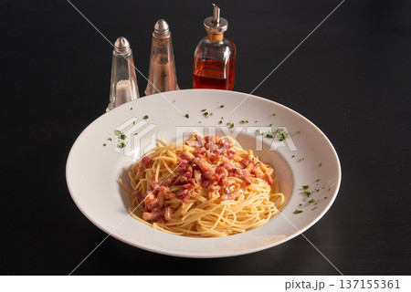 Plate of Carbonara pasta on a black wooden table Plate of Carbonara pasta on a black wooden table 137155361