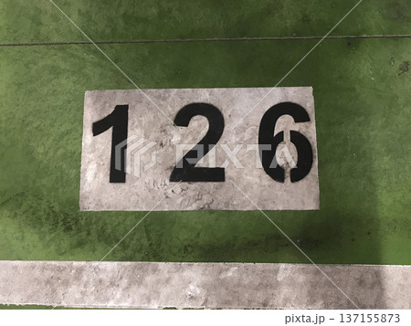 number painted in white on a green background on the floor of a subway parking garage number painted in white on a green background on the floor of a subway parking garage 137155873