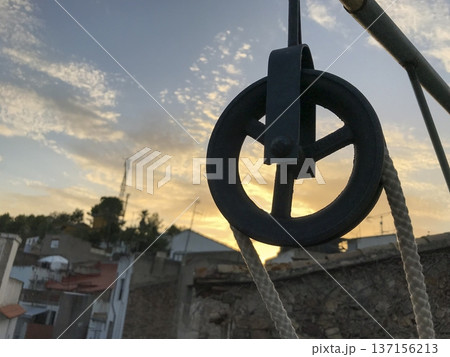 metal pulley with rope and out-of-focus rural background metal pulley with rope and out-of-focus rural background 137156213