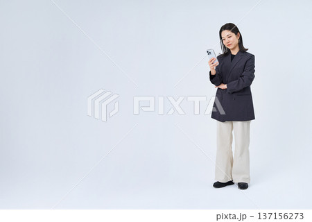 スマートフォンを操作する若いビジネスウーマン スマートフォンを操作する若いビジネスウーマン 137156273