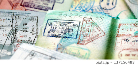 Big amount of passport pages full of colorful stamps after travel and border crossing. Tourism and border control concept. Immigration and travel around the world Big amount of passport pages full of colorful stamps after travel and border crossing. Tourism and border control concept. Immigration and travel around the world 137156495