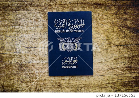 Yemeni passport on table close up. Official identification document book for citizens of Yemen. Concept of travel and tourism Yemeni passport on table close up. Official identification document book for citizens of Yemen. Concept of travel and tourism 137156553