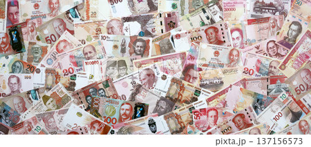 Various currencies money bills banknotes in red color. Many cash bills from different countries in big pile close up. World economy and currency exchange concept 137156573
