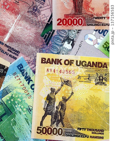 Ugandan shilling paper banknotes pile on table. Uganda UGX currency money bills in big amount. Concept of economics, taxation and banking in Uganda 137156583