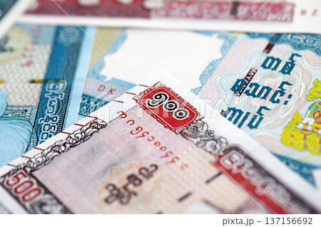 Myanmar kyat paper banknotes pile on table. Myanmar MMK currency money bills in big amount. Concept of economics, taxation and banking in Myanmar Myanmar kyat paper banknotes pile on table. Myanmar MMK currency money bills in big amount. Concept of economics, taxation and banking in Myanmar 137156692