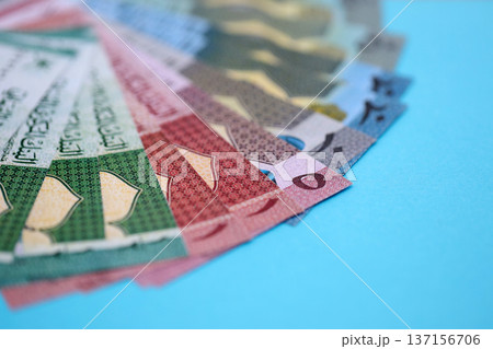 Omani rial paper banknotes fan on blue table. Oman OMR currency money bills in big amount. Concept of economics, taxation and banking in Oman 137156706