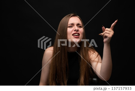 Woman feeling frustration and anger, screaming while pointing finger up, expressing strong negative emotions, stress 137157933
