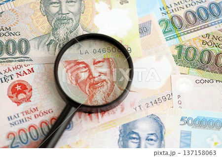 Vietnamese dong currency money bills and magnifying glass close up. The concept of financial monitoring and taxation 137158063