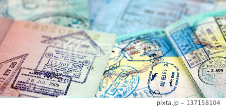 Big amount of passport pages full of colorful stamps after travel and border crossing. Tourism and border control concept. Immigration and travel around the world 137158104