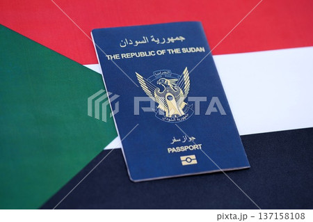 Sudanese passport on flag close up. Official identification document book for citizens of Sudan. Concept of travel and tourism Sudanese passport on flag close up. Official identification document book for citizens of Sudan. Concept of travel and tourism 137158108