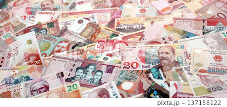 Various currencies money bills banknotes in red color. Many cash bills from different countries in big pile close up. World economy and currency exchange concept Various currencies money bills banknotes in red color. Many cash bills from different countries in big pile close up. World economy and currency exchange concept 137158122