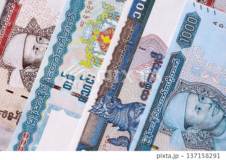 Myanmar kyat paper banknotes pile on table. Myanmar MMK currency money bills in big amount. Concept of economics, taxation and banking in Myanmar Myanmar kyat paper banknotes pile on table. Myanmar MMK currency money bills in big amount. Concept of economics, taxation and banking in Myanmar 137158291