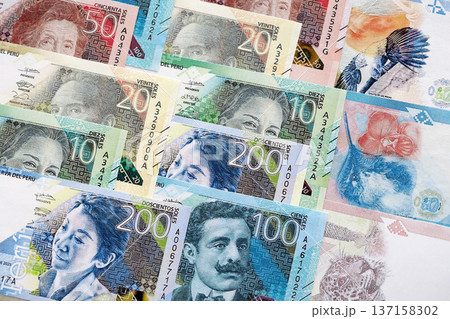 Peruvian sol paper banknotes pile on table. Peru PEN currency money bills in big amount. Concept of economics, taxation and banking in Peru Peruvian sol paper banknotes pile on table. Peru PEN currency money bills in big amount. Concept of economics, taxation and banking in Peru 137158302