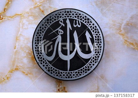 Sign with Islam inscription on table in mosque. Details of arabic calligraphy on paper sticker. Concept of Islam religion and praying in arabic countries 137158317