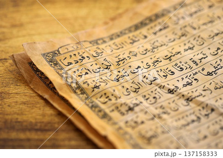 Pages of Al Quran Muslim old holy book on table in mosque. Details of arabic calligraphy in islamic book. Concept of Islam religion and praying in arabic countries 137158333