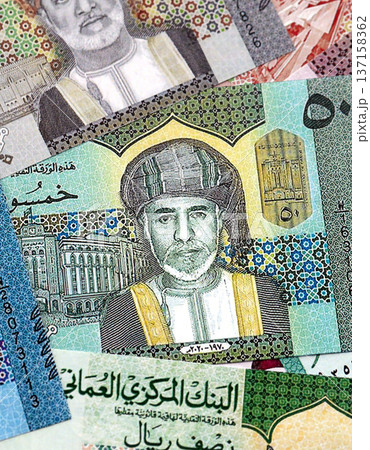 Omani rial paper banknotes pile on table. Oman OMR currency money bills in big amount. Concept of economics, taxation and banking in Oman 137158362