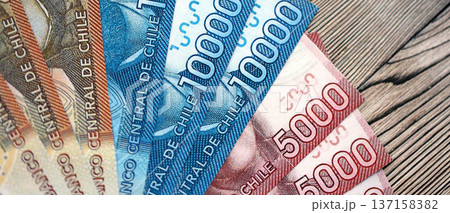 Big amount of chilean pesos money bills banknotes on wooden table. Huge quantity of paper money from Chile country close up. Concept of business and economy in Chile Big amount of chilean pesos money bills banknotes on wooden table. Huge quantity of paper money from Chile country close up. Concept of business and economy in Chile 137158382