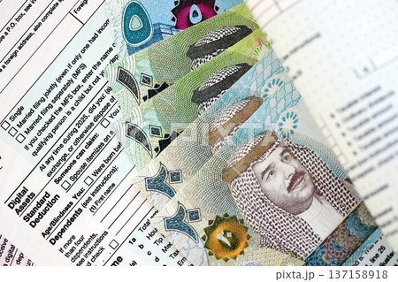 Bahraini dinar money bills on tax form close up. Taxation and accounting concept Bahraini dinar money bills on tax form close up. Taxation and accounting concept 137158918