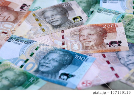 South African rand paper banknotes pile on table. South Africa ZAR currency money bills in big amount. Concept of economics, taxation and banking in South Africa South African rand paper banknotes pile on table. South Africa ZAR currency money bills in big amount. Concept of economics, taxation and banking in South Africa 137159119