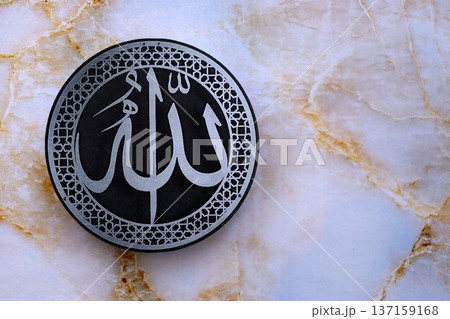 Sign with Islam inscription on table in mosque. Details of arabic calligraphy on paper sticker. Concept of Islam religion and praying in arabic countries 137159168